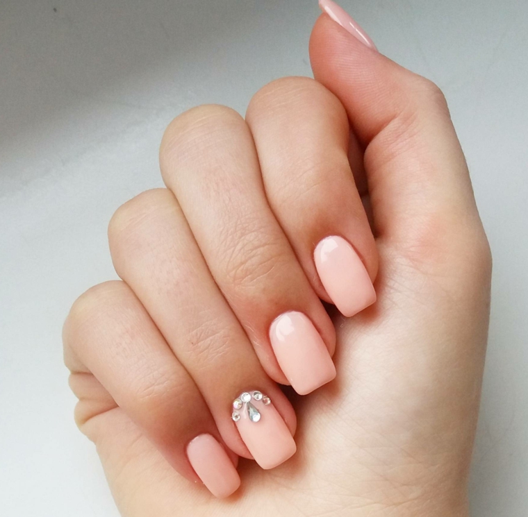 Unghie gel semplici, smalto di colore rosa, decorazione con brillantini 