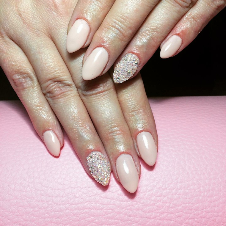 Accent nail con piccoli brillantini sul dito anulare, colorare con smalti di colore rosa 