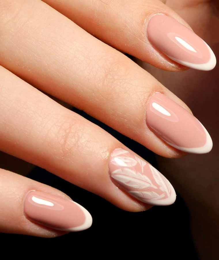 elegante manicure con unghie neutre con top brillante e anulare con delle piume bianche