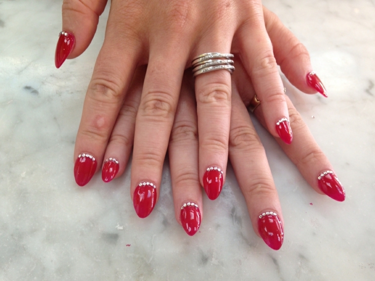 gel unghie rosso, una manicure impreziosita da dei piccoli glitter interno alla cuticola